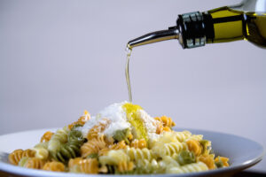Olivenöl wird auf Pasta gegeben