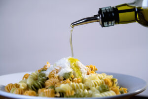 Olivenöl wird auf Pasta gegeben