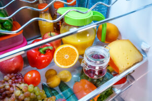 offener Kühlschrank mit Orangensaft und Obst