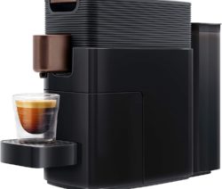 Schwarze Kaffeemaschine mit Glas Espresso auf der Tropfschale.
