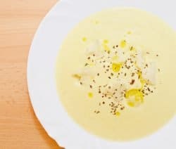 Leckeres Parmesansüppchen, angerichtet mit Olivenöl und Basilikum-Kräutern