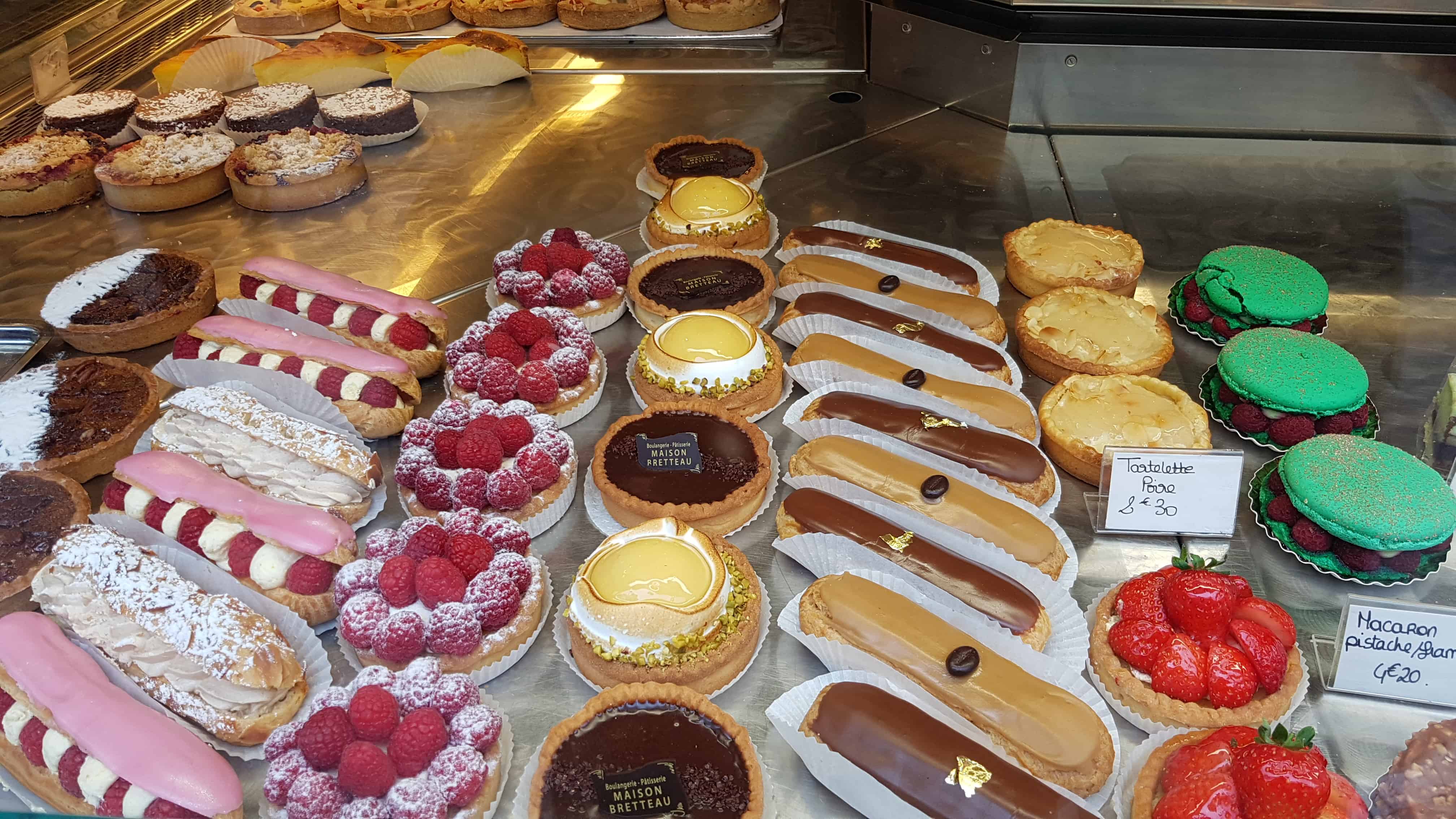 Französische Patisserie mit kleinen Törtchen, Eclairs, Macarons