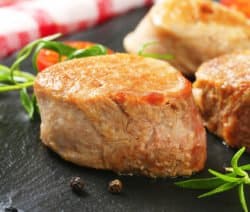 Pan seared pork medallions on black slate