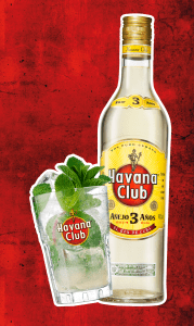 Eine Flasche Havana Club Rum neben einem Glas Mojito mit Minzblättern auf rotem Hintergrund.
