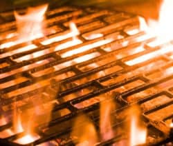 Ein heißer Grillrost mit lodernden Flammen darunter.