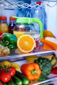offener Kühlschrank gefüllt mit gesunden Lebensmitteln