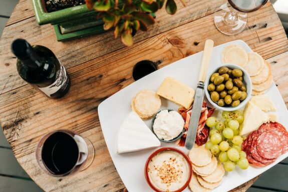 Käseplatte anrichten: leckere Käseplatte mit Rotwein