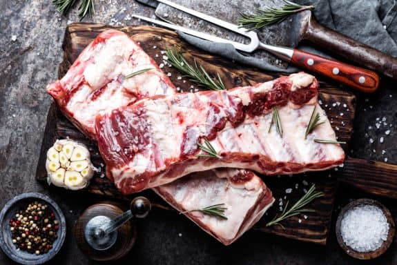 raw meat ribs on wooden cutting board