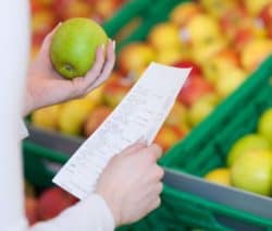 Frau im Supermarkt prüft Obst