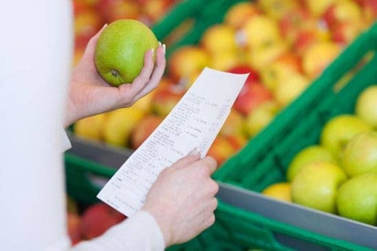 Frau im Supermarkt prüft Obst