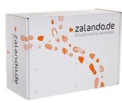 Weiße Zalando-Schuhbox mit orangefarbenen Schuhabdrücken und dem Slogan 'Schuhe online bestellen'.