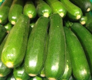 Ein Stapel grüner Zucchini liegt dicht nebeneinander.